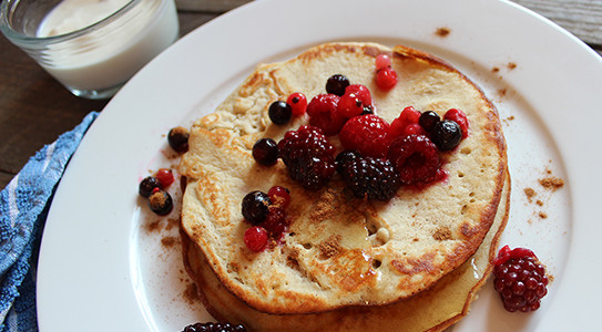 a plate of pancakes topped with berries