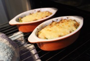 Sizzling cauliflower cheese bake coming out from under the grill